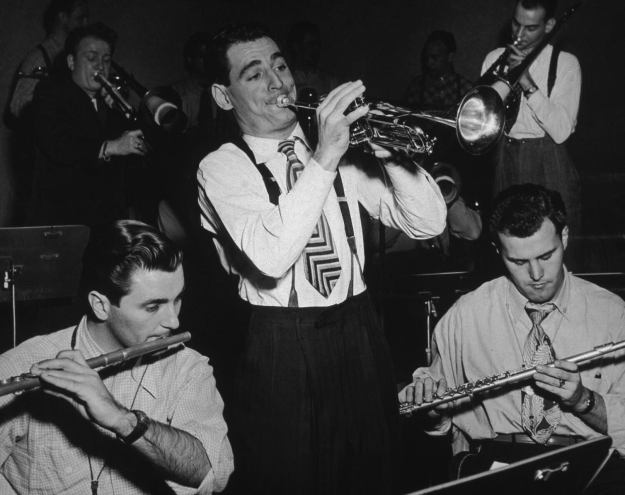 A man playing trumpet amid other musicians