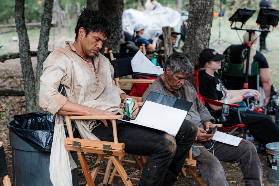 Actors Martin Sensmeier and Esai Morales rest and review the script in-between takes of filming "Cottonmouth."