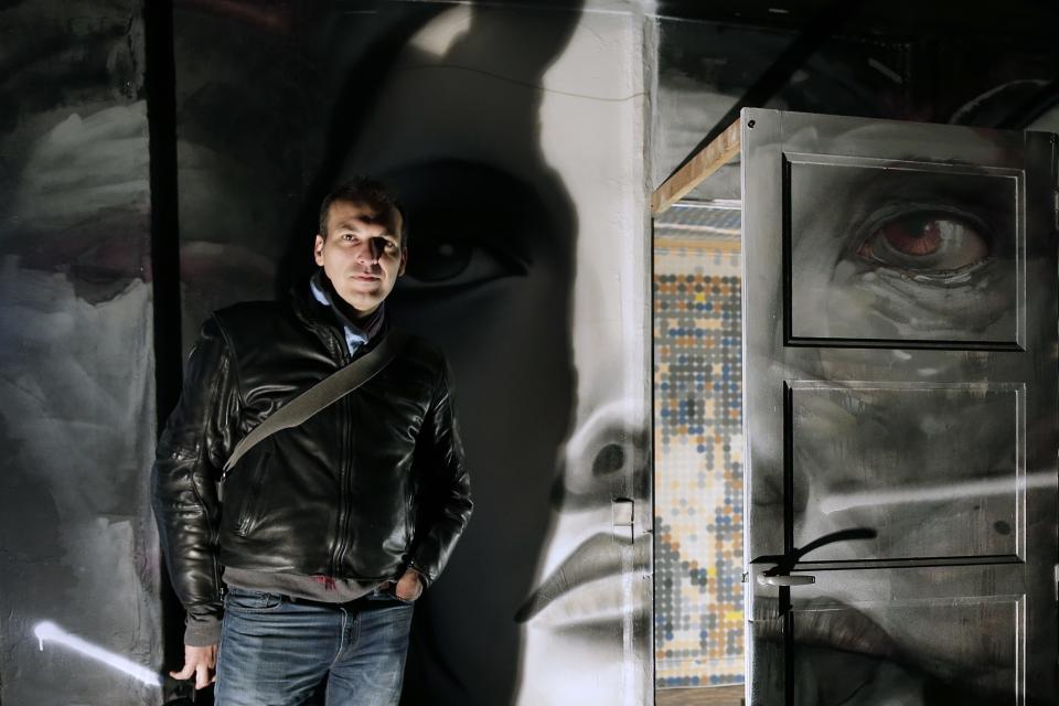 Paris art gallery owner Mehdi Ben Cheikh poses in a living room painted by French street artists Bom K and Liliwenn at the street art project tower "Paris Tour 13" in Paris