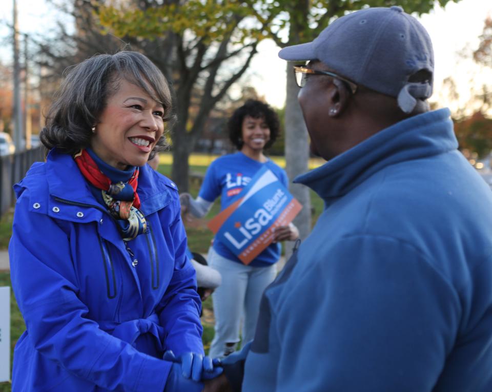 U.S. Congresswoman Lisa Blunt Rochester (left) shakes hands with Randell Knight (right) outside of a polling site in Wilmington.