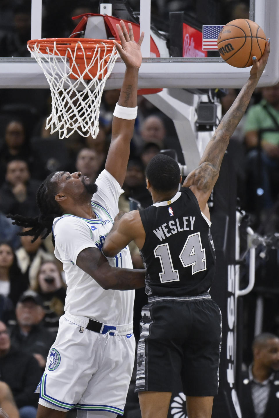 San Antonio Spurs' Blake Wesley (14) attempts to shoot against Minnesota Timberwolves' Naz Reid during the first half of an NBA basketball game, Saturday, Jan. 27, 2024, in San Antonio. (AP Photo/Darren Abate)