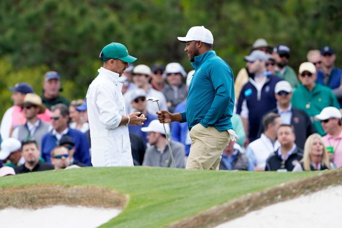 Harold Varner III smiles at his caddie, Chris Rice, on the seventh green during the second round of The Masters on Friday in Augusta, Ga.