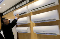 A visitor takes a photo of Gree's air conditioners during the China Import and Export Fair, also known as Canton Fair, in the southern city of Guangzhou, China April 16, 2018. REUTERS/Tyrone Siu