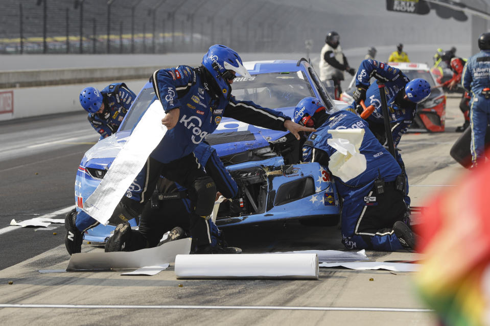 Crew members for the car driven by Ricky Stenhouse Jr. work on the car after a crash in the pit area during a NASCAR Cup Series auto race at Indianapolis Motor Speedway in Indianapolis, Sunday, July 5, 2020. (AP Photo/Darron Cummings)