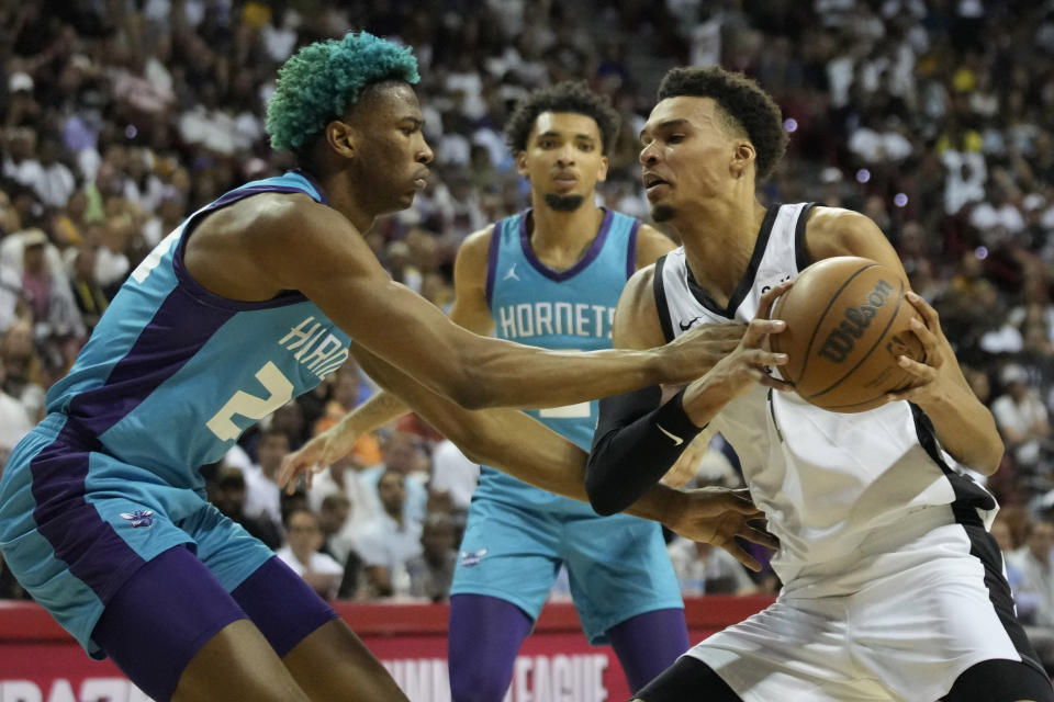 San Antonio Spurs' Victor Wembanyama, right, drives against Charlotte Hornets' Kai Jones, left, during the first half of an NBA summer league basketball game Friday, July 7, 2023, in Las Vegas. (AP Photo/John Locher)