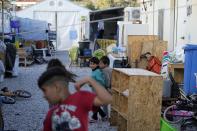 Migrants gather outside their container houses before the visit of Pope Francis at the Karatepe refugee camp, on the northeastern Aegean island of Lesbos, Greece, Sunday, Dec. 5, 2021. Pope Francis is returning to Lesbos, the Greek island that was at the heart of a massive wave of migration into Europe six years ago, after making pointed criticism of European governments on the handling of the crisis during a visit to two hard-hit countries. (AP Photo/Alessandra Tarantino)