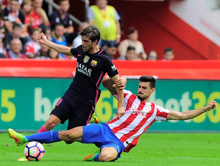 Barcelona's midfielder Sergi Roberto (L) clashes with Sporting Gijon's midfielder Sergio Alvarez on September 24, 2016