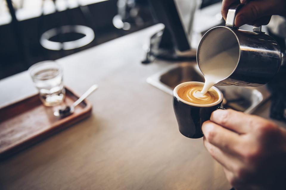 barista pouring coffee in cafe