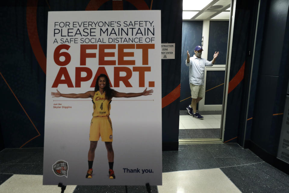 Matt Zeysing, right, curator at the Naismith Memorial Basketball Hall of Fame steps into an elevator near a safe-distancing sign, left, at the museum, in Springfield, Mass., Tuesday, June 23, 2020. The museum is scheduled to reopen in the beginning of July 2020 with a whole new look after a $22 million renovation. (AP Photo/Steven Senne)