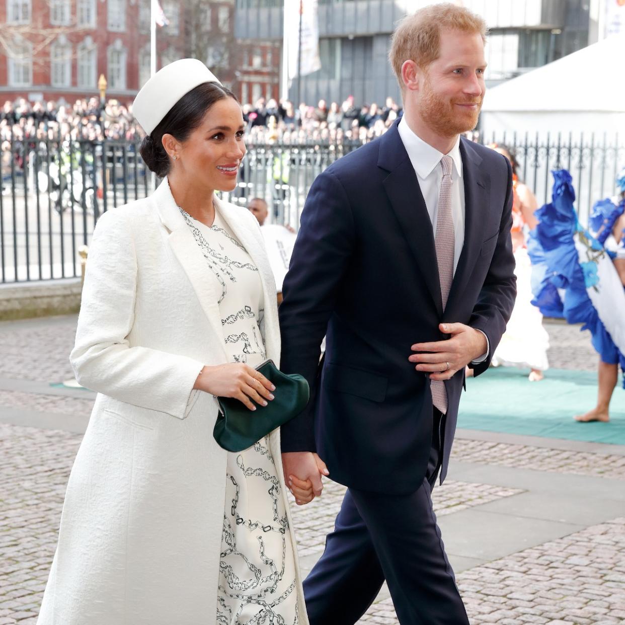  Prince Harry and Meghan Markle walk next to one another 