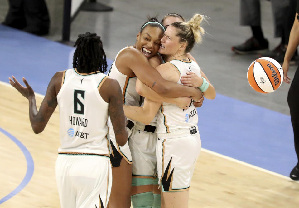 New York Liberty players Betnijah Laney, left center, hugs teammates Sabrina Ionescu and Sami Whitcomb, right, after winning a WNBA basketball game over the Chicago Sky Sunday, May 23, 2021, in Chicago. (AP Photo/Eileen T. Meslar)