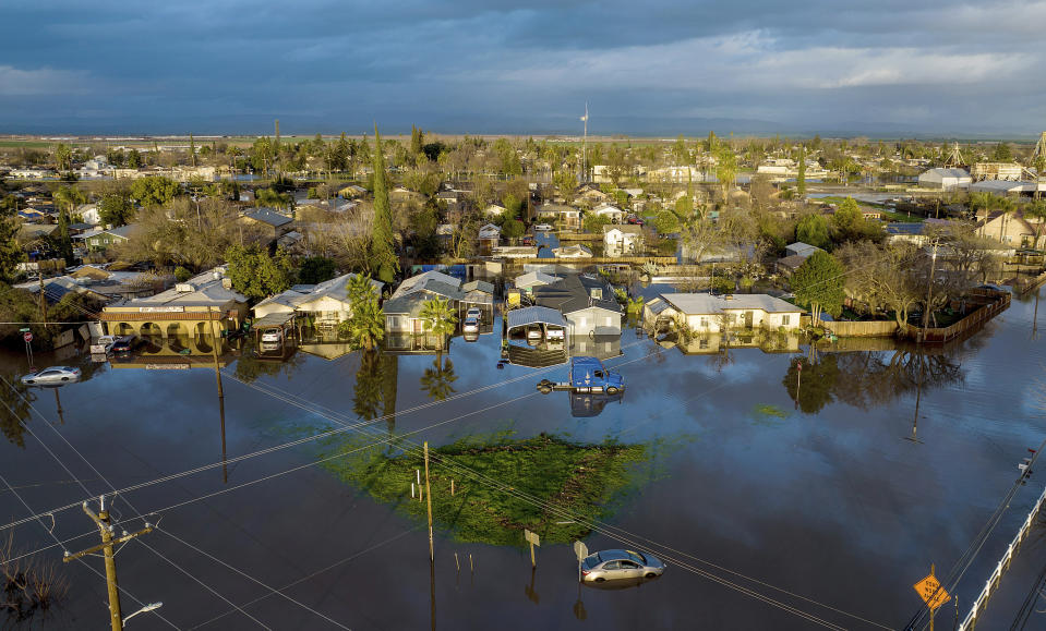 Following days of rain, floodwaters surround homes and vehicles in the Planada community of Merced County, Calif., on Tuesday, Jan. 10, 2023. (AP Photo/Noah Berger)
