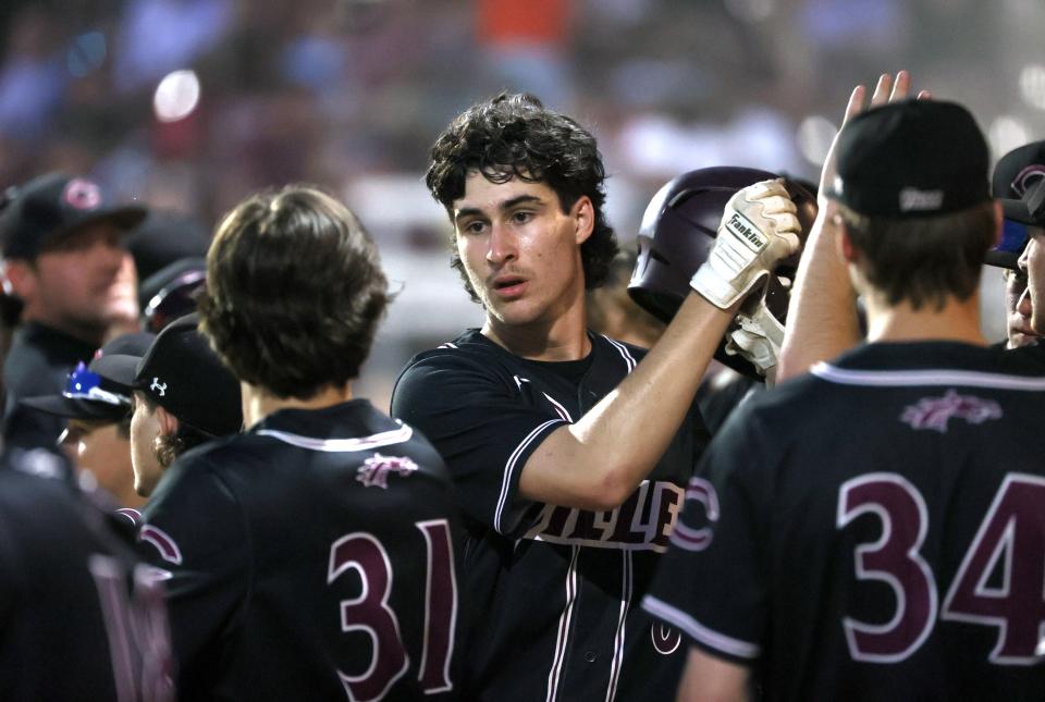 Collierville's Thomas Crabtree celebrates with his teammates after scoring a run against Houston during their Region Final at Collierville High School on Wednesday, May 18, 2022.