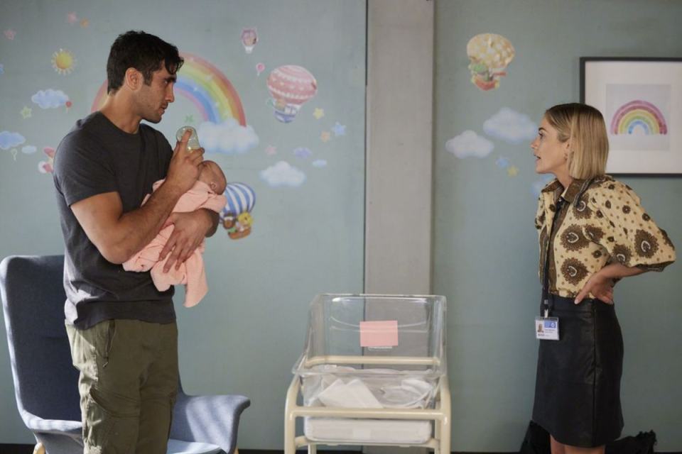 Tane holding baby Maia with Harper in the hospital on Home and Away