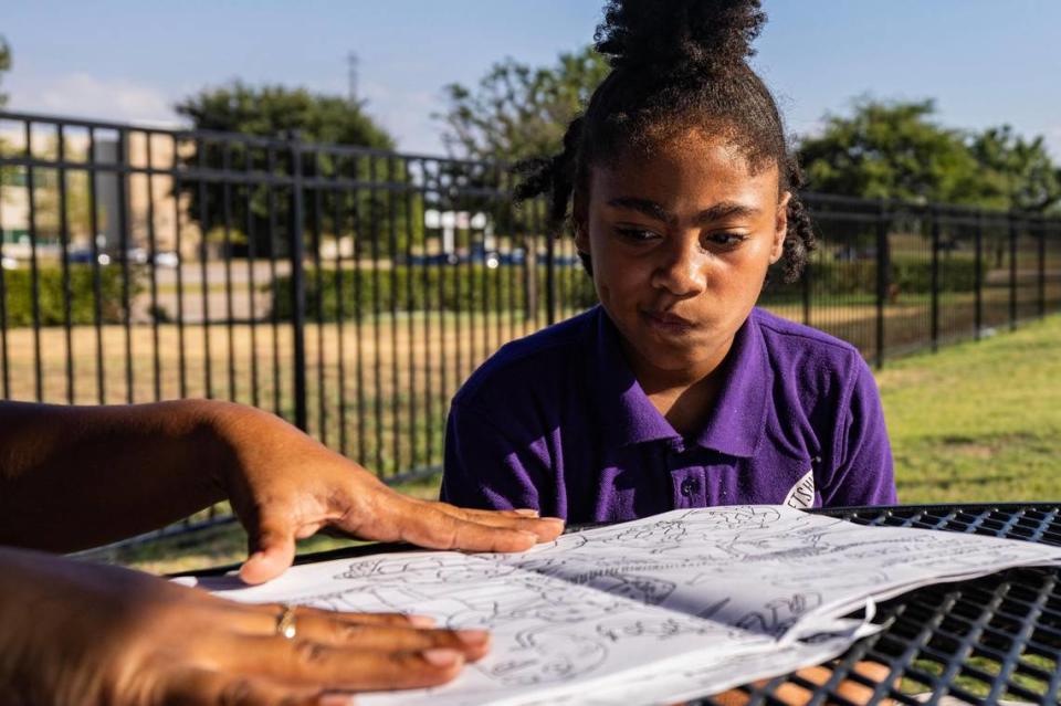 LaShanta Mire, left, helps her daughter Malaysia Campbell, 8, build her reading skills at the park in the Patriot Pointe Apartments in Fort Worth on Wednesday. After taking a reading assessment over the summer, Campbell was told she has a kindergarten reading level as a third grader despite coming home with A’s on her report cards.