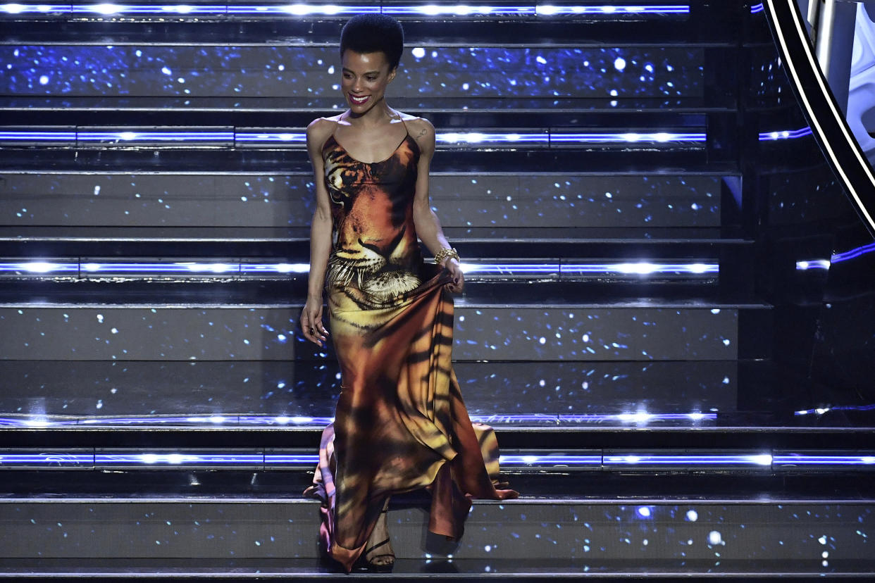 Lorena Monroe Cesarini appears on the stage of the Ariston theater on the occasion of the Sanremo songs Festival, in San Remo, Italy, Wednesday, Feb. 2, 2022. A Black Italian actress said she received on-line harassment after her appearance as a guest on Italy’s annual Sanremo music festival was announced. Lorena Monroe Cesarini told a live and TV audience on Wednesday that “evidently for someone, the color of my skin is a problem,” reading some messages she received on social media. They included messages saying she didn’t deserve being a guest at the music festival and that “they called you because you are black,” and one saying “maybe they called you to wash the staircase or put the flowers in vases.” (Matteo Rasero/LaPresse via AP)