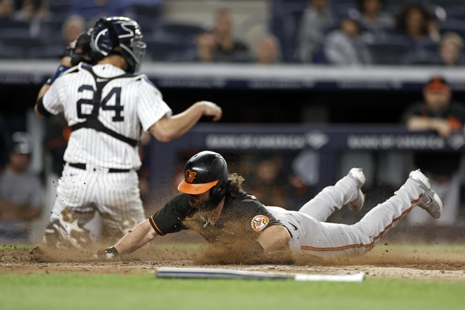 Baltimore Orioles' Ryan McKenna, right, scores a run past New York Yankees catcher Gary Sanchez (24) during the 10th inning of a baseball game on Friday, Sept. 3, 2021, in New York. (AP Photo/Adam Hunger)