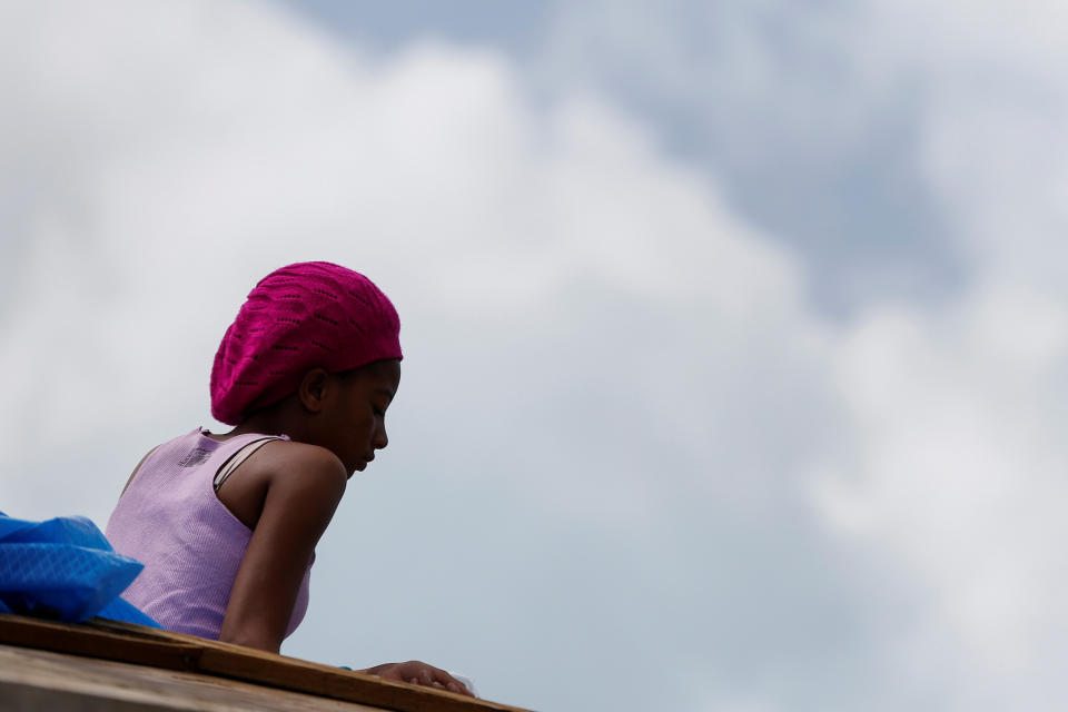 Che Niesha,16, from Barbuda, sits on the roof of a home at Codrington on the island of Barbuda just after a month after Hurricane Irma struck the Caribbean islands of Antigua and Barbuda