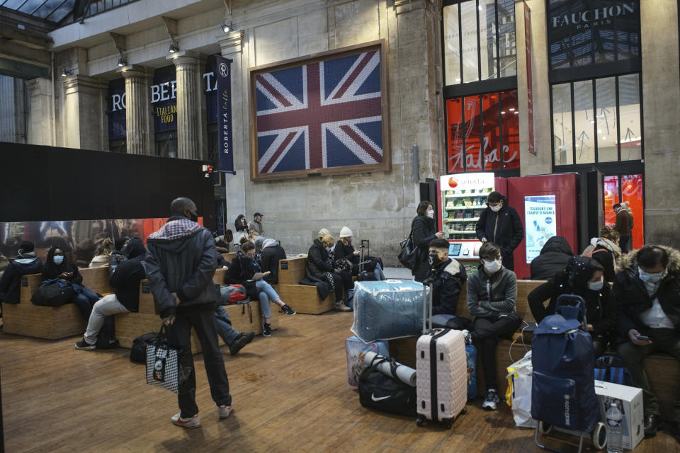 Passengers wearing face mask wait next to the Eurostar Terminal at Gare du Nord train station in Paris, Monday Dec. 21, 2020. France is banning all travel from the U.K. for 48 hours in an attempt to make sure that a new strain of the coronavirus in Britain doesn't reach its shores. (AP Photo/Lewis Joly)