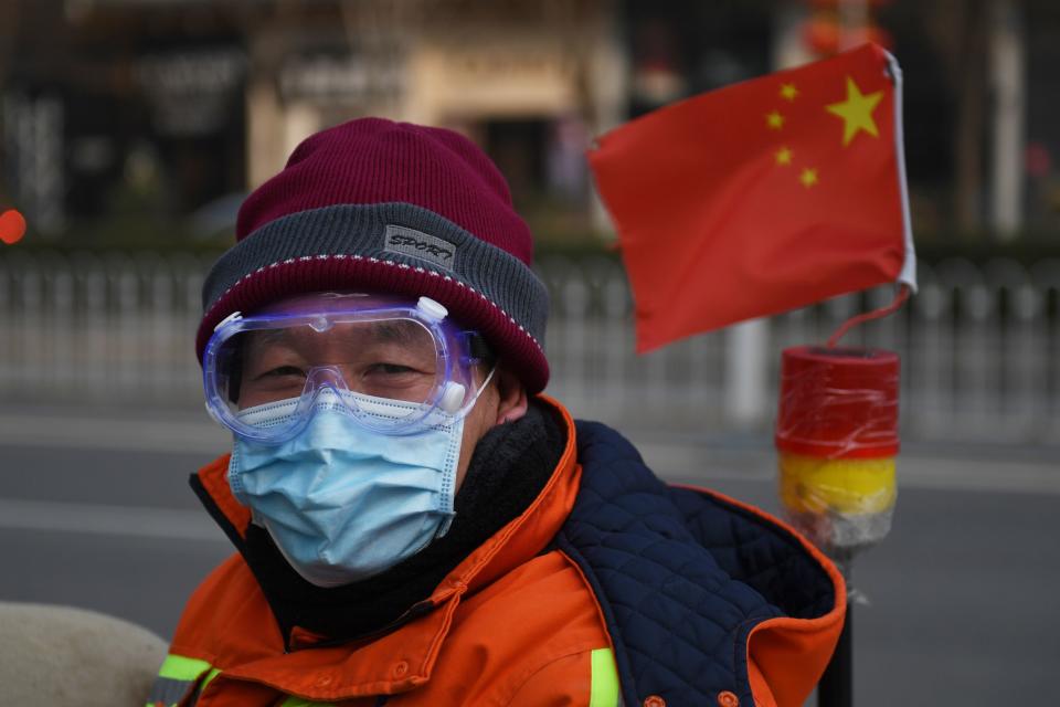 A cleaner wears a mask and goggles as he commutes on a street in Beijing on February 11, 2020. - The death toll from a new coronavirus outbreak surged past 1,000 on February 11 as the World Health Organization warned infected people who have not travelled to China could be the spark for a "bigger fire". (Photo by GREG BAKER / AFP) (Photo by GREG BAKER/AFP via Getty Images)