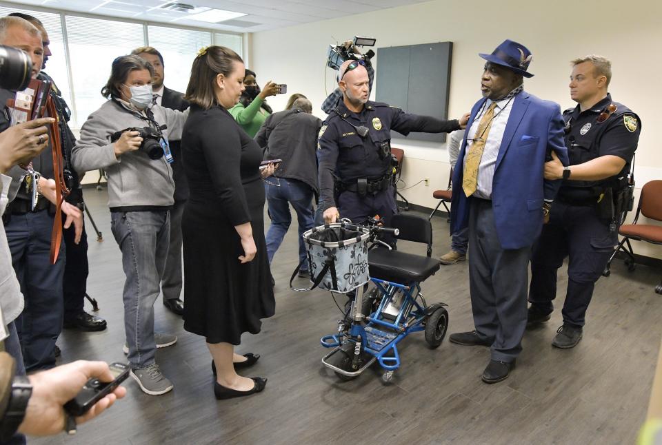 Northside Coalition of Jacksonville community leader Ben Frazier is handcuffed by a police officer on Jan. 4 after refusing to leave Gov. Ron DeSantis' news conference in a Department of Children and Families office.