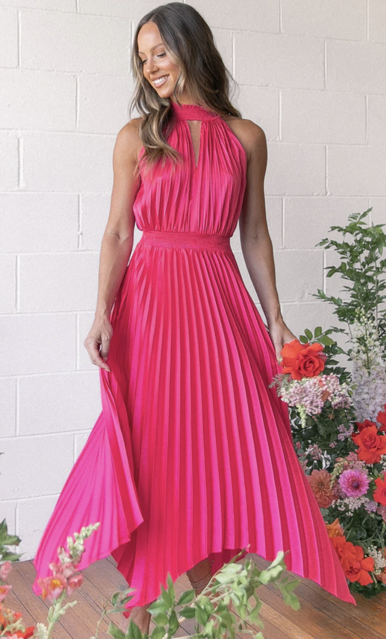 A model in a hot pink pleated long gown with high neck and exposed shoulders. Dominique Dress, $99, from Petal + Pup