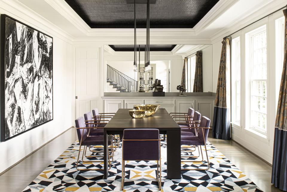 “When you walk into the house, you see the dining room and the living room, so they needed to talk to one another,” says Loya. She added a mirror to the wet bar to make the room appear more spacious (“I love mirrors. I think they are miracle workers!”), a geometric rug by Carol Piper as a nod to the living room, and silk custom drapes from Brentano and Designers Guild. The recessed ceiling is papered in a black leather-look Elitis wall covering to give the room more texture and depth.