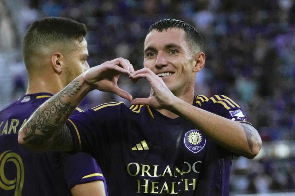 Orlando City defender Kyle Smith (24) makes a heart shape toward fans after scoring a goal against Atlanta United during the first half of an MLS soccer match, Saturday, May 27, 2023, in Orlando, Fla. (AP Photo/John Raoux)