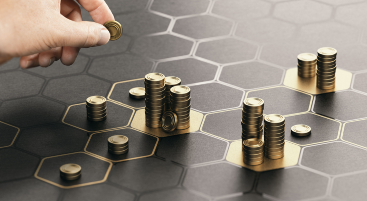 Human hand stacking coins over a black background with hexagonal golden shapes. Concept of investment management and portfolio diversification. Composite image between a hand photography and a 3D back