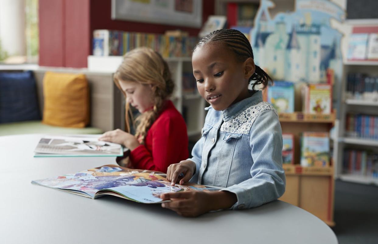 In an increasingly digital world, children still enjoy the sensory power of being able to touch the books they read. <a href="https://www.gettyimages.com/detail/photo/schoolgirls-reading-books-in-school-library-royalty-free-image/1049277458?phrase=touch+reading&adppopup=true" rel="nofollow noopener" target="_blank" data-ylk="slk:Klaus Vedfelt via Getty Images;elm:context_link;itc:0;sec:content-canvas" class="link ">Klaus Vedfelt via Getty Images</a>