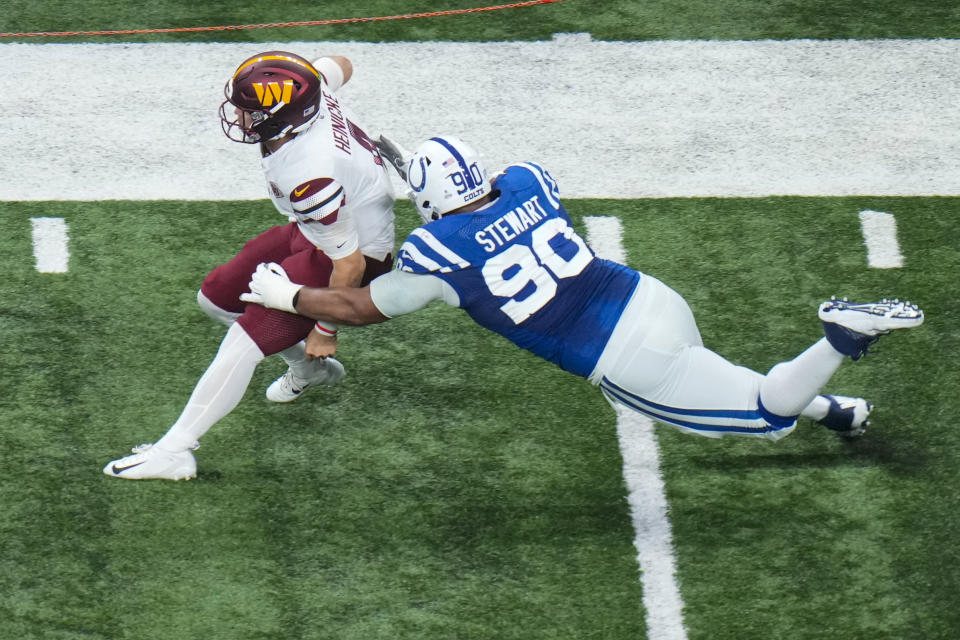 Washington Commanders quarterback Taylor Heinicke (4) is tackled by Indianapolis Colts defensive tackle Grover Stewart (90) in the first half of an NFL football game in Indianapolis, Sunday, Oct. 30, 2022. (AP Photo/AJ Mast)