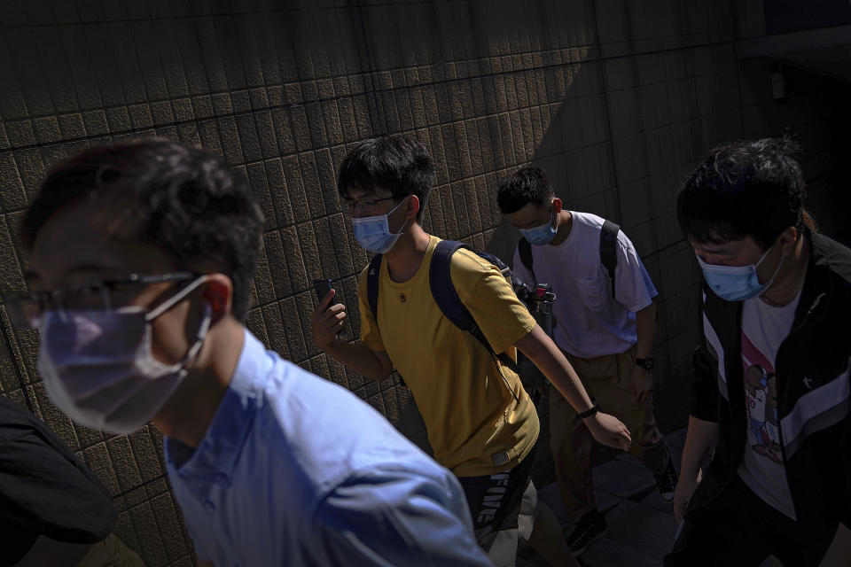 People wearing face masks to help curb the spread of the coronavirus walks out of an underpass tunnel as they head to work in Beijing, Thursday, June 10, 2021. (AP Photo/Andy Wong)