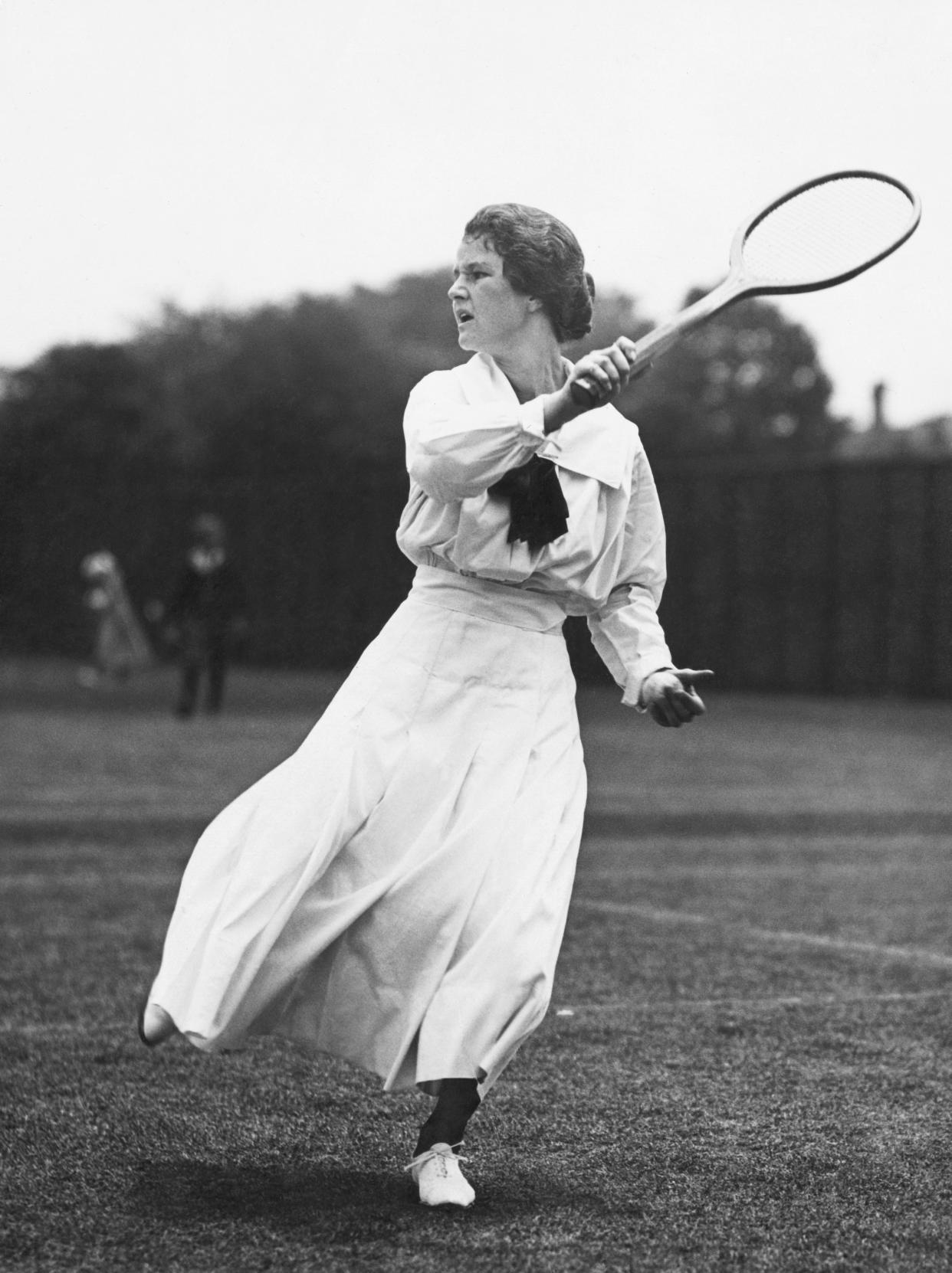 Woman swinging tennis racket circa 1900