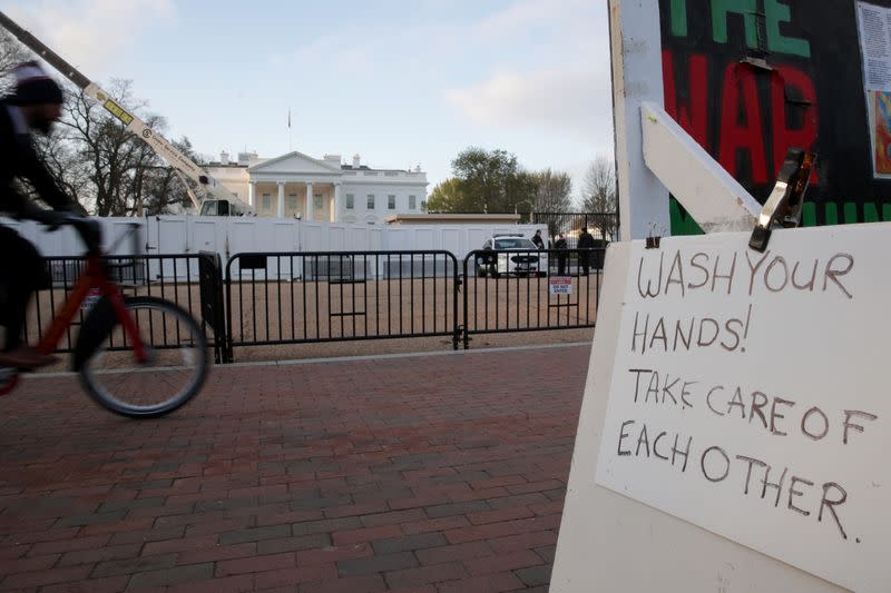 A sign reminding people to "wash your hands" during the current coronavirus outbreak hangs on the semi-permanent anti-nuclear weapons White House Peace Vigil across from White House in Washington