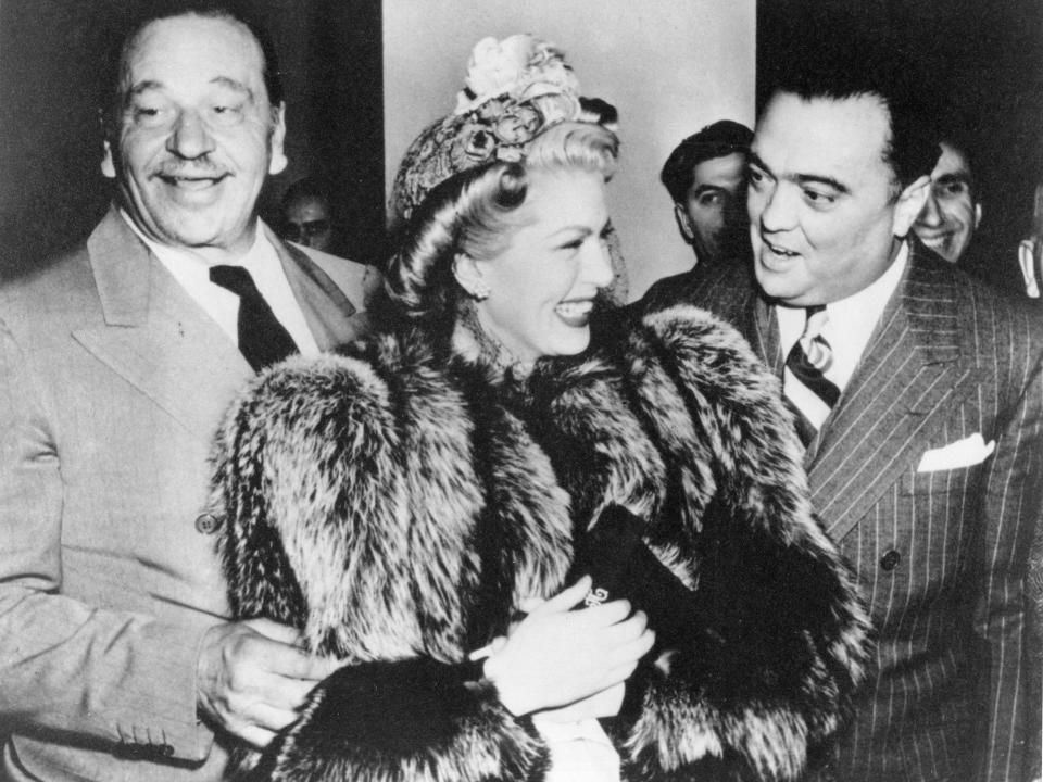 J. Edgar Hoover laughs with actors Wallace Beery and Lana Turner.