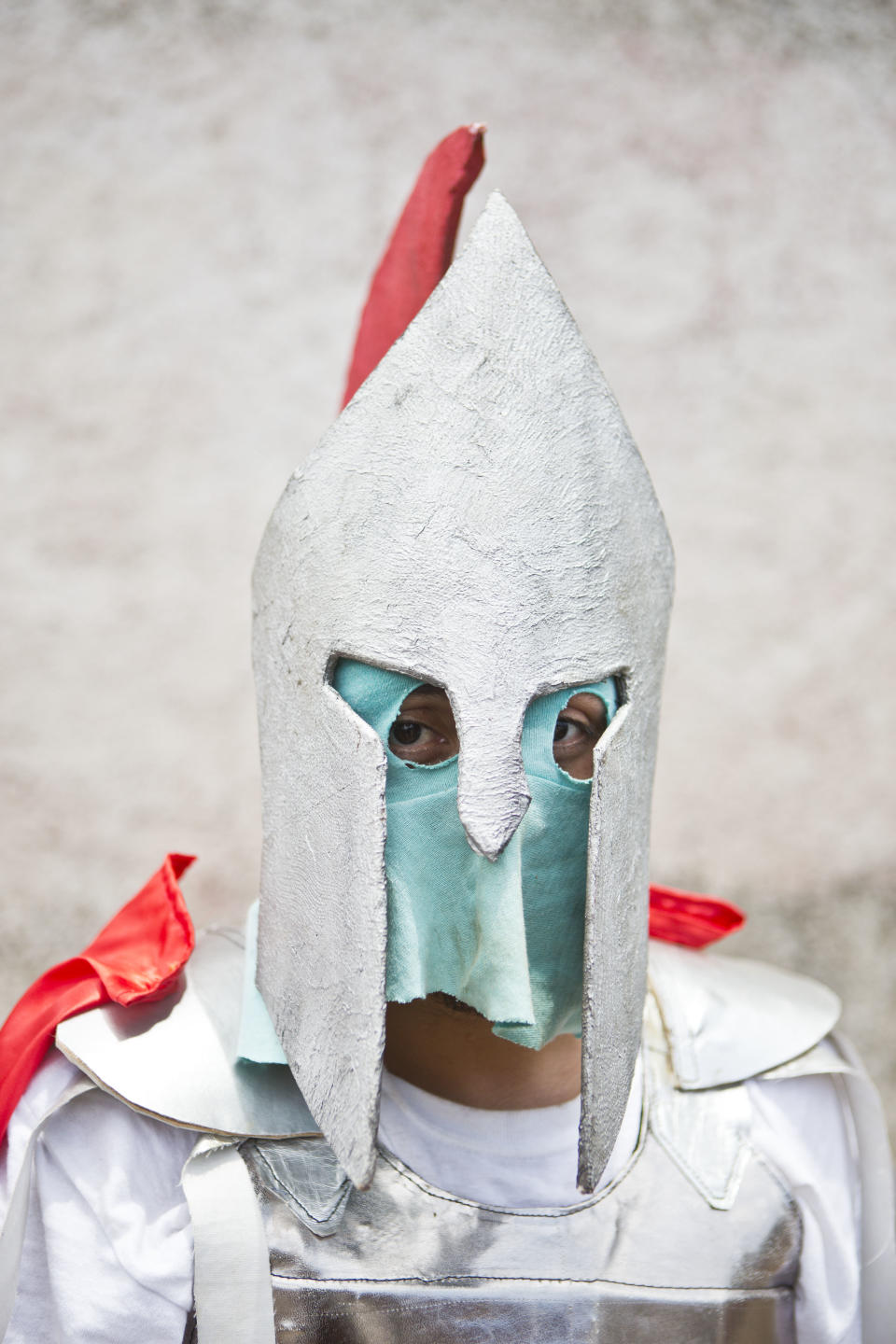 In this April 18, 2014 photo, a youth wearing his hand made mask and dressed up as Roman centurion poses for a picture as he takes a break from the "Los Encadenados," or The Chained Ones procession on Good Friday during Holy Week in Masatepe, Nicaragua. For the past 130 years, residents of Masatepe have celebrated Good Friday by dressing up in colorful masks and costumes, and dragging chained “Judases” through the streets of this town in western Nicaragua. (AP Photo/Esteban Felix)