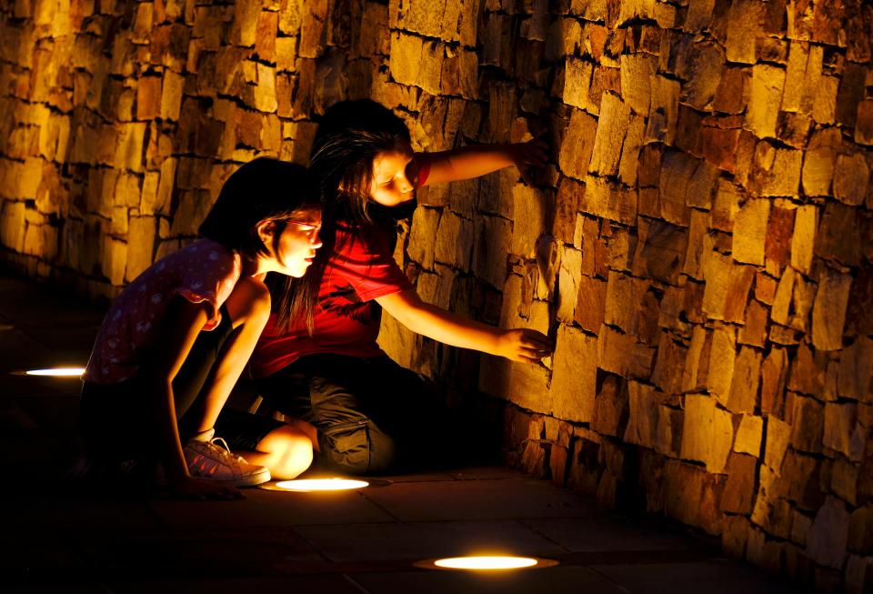 Two girls play at the Remembrance Gate on Sept. 19, 2021, during the second day of the grand opening of the First Americans Museum.