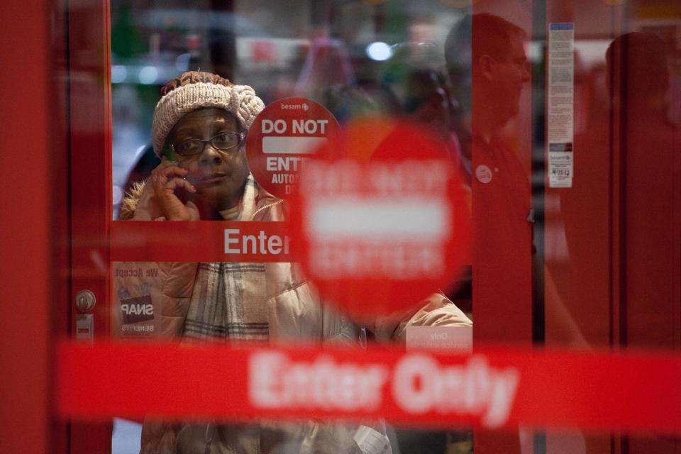 One of the first in line, a woman talks on her cellphone next to the entrance of Target just minutes before the start of their Black Friday sales event in Flint, Mich. on Thursday, Nov. 22, 2012.