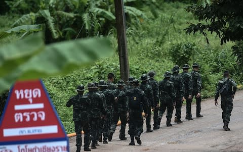 Thai soldiers walk into to the Tham Luang cave area - Credit: YE AUNG THU /AFP