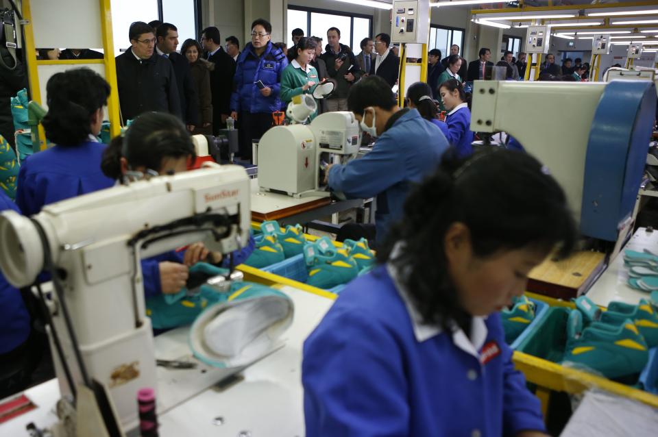 Officials from the G20 Seoul Conference visit a factory of a South Korean company at the Joint Industrial Park in Kaesong, a few miles inside North Korea from the heavily fortified border December 19, 2013. North Korea hosted a group of foreign officials and journalists on Thursday in a rare opening of the industrial zone jointly run with the South, a week after the regime executed the powerful uncle of leader Kim Jong Un. North and South Korean officials also held meetings at the Kaesong complex on Thursday to discuss the operations of the factory park, their first contact since the purge of Jang Song Thaek, considered the second-most powerful man in the country. REUTERS/Kim Hong-Ji (NORTH KOREA - Tags: BUSINESS EMPLOYMENT POLITICS)