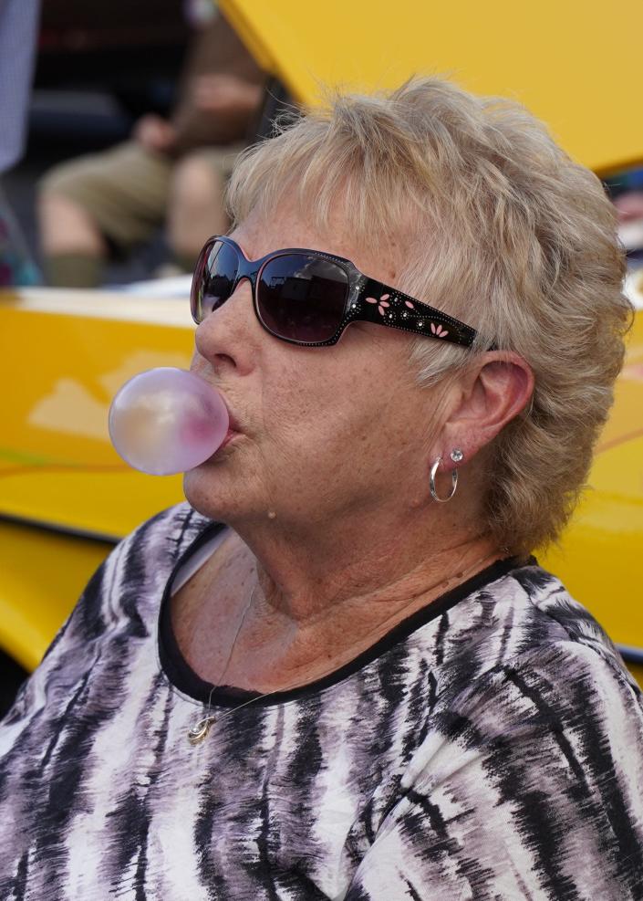 Libby Wilson of Adrian blows a bubblegum bubble Tuesday, Aug. 9, 2022, in downtown Adrian during the 20th anniversary celebration at Nova's Soda Pop Candy Shop, 105 E. Church St.