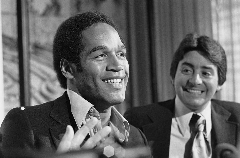 FILE - O.J. Simpson, left, smiles next to San Francisco 49ers owner Edward DeBartolo Jr. at a news conference where the 49ers announced that Simpson had been traded to them from the Buffalo Bills, in San Francisco, March 24, 1978. San Francisco dealt five draft picks to Buffalo in 1978 for hometown star O.J. Simpson, who was about to turn 31 and coming off knee surgery. (AP Photo/Sal Veder, file)