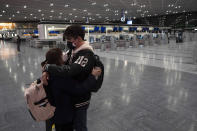 Una pareja se abraza en un aeropuerto de Narita casi vacío por la pandemia del coronavirus. (AP Photo/Jae C. Hong)