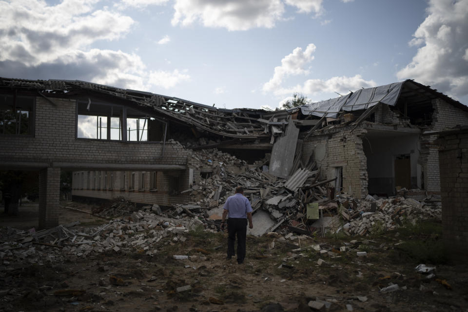 Oleksandr Pishchyk, a school director, stands in front of the school library that was destroyed by shelling in Kupiansk, Ukraine, Wednesday, Aug. 23, 2023. There are still 451 children in Kupiansk who's parents have refused evacuation pleas, despite intensified offensive operations by Russian forces in recent weeks. (AP Photo/Bram Janssen)