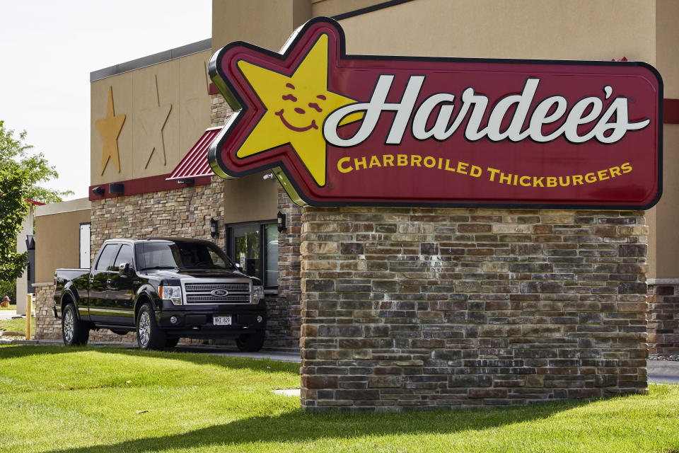 A vehicle approaches the drive-thru window at a Hardee's fast food restaurant in Omaha, Neb., Tuesday, July 7, 2020. Some big corporate names are on the government's list of 650,000 recipients of coronavirus relief loans despite the controversy that prompted other high-profile businesses to return billions of dollars in loan. Among the companies on the list are Boddie-Noell Enterprises, owner of 346 Hardee's restaurants, who received between $5 million and $10 million. (AP Photo/Nati Harnik)