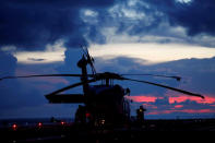 An SH-60K Sea Hawk helicopter on the flight deck of Japanese carrier Kaga is silhouetted against the sky after a joint drill with a British frigate in the Indian Ocean, September 26, 2018. Picture taken on September 26, 2018. REUTERS/Kim Kyung-Hoon