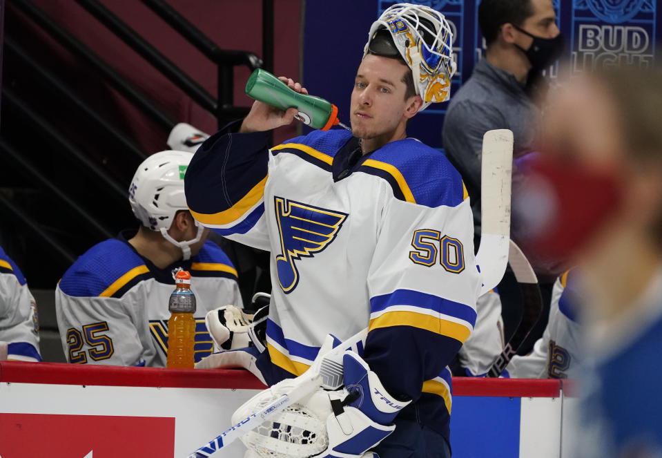 St. Louis Blues goaltender Jordan Binnington sprays water from his bottle during a timeout in the second period of the team's NHL hockey game against the Colorado Avalanche on Wednesday, Jan. 13, 2021, in Denver. (AP Photo/David Zalubowski)