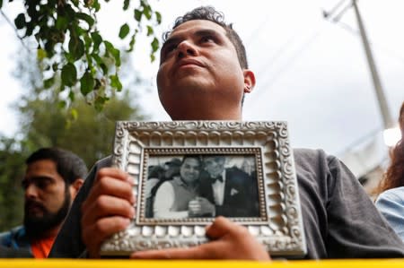 Neighbor Ivan Gonzalez holds a picture of Jose Jose and himself as he pays tribute to the Mexican singer and songwriter, who died in Miami after complications following treatment for pancreatic cancer, at his statue in Mexico City