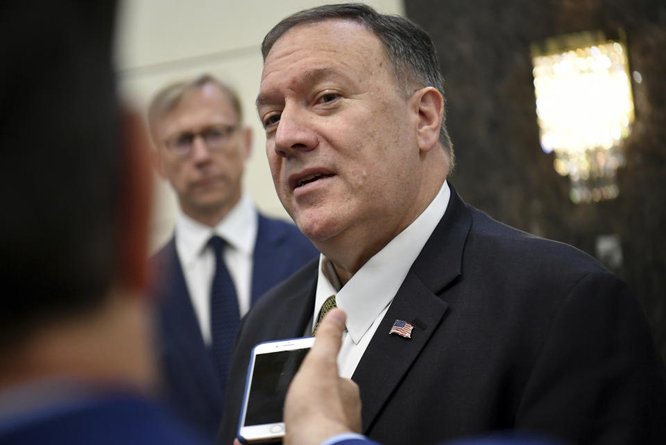 U.S. Secretary of State Mike Pompeo speaks to the media before departing from al-Bateen Air Base in Abu Dhabi, United Arab Emirates, Thursday, Sept. 19, 2019, as U.S. special representative on Iran Brian Hook, left, listens. (Mandel Ngan/Pool via AP)