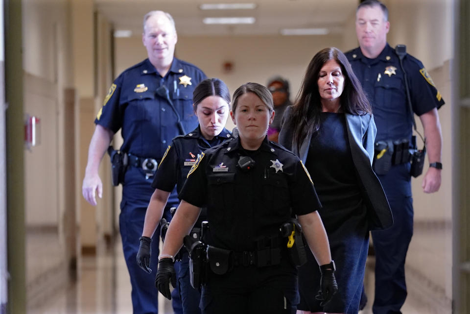 Former Pennsylvania Attorney General Kathleen Kane, second from right, is led to court as she arrives for a hearing on an alleged probation violation, at the Montgomery County Courthouse in Norristown, Pa., Monday, May 23, 2022. Pennsylvania's former top law enforcement officer, who served jail time for leaking secret investigative files and lying about it, faces the prospect of more time behind bars after she was arrested for drunken driving in March. (AP Photo/Matt Rourke)